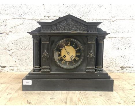 A Victorian slate mantle clock of architectural form, the arched pediment over frieze with Romo-Grecian imagery, above fluted