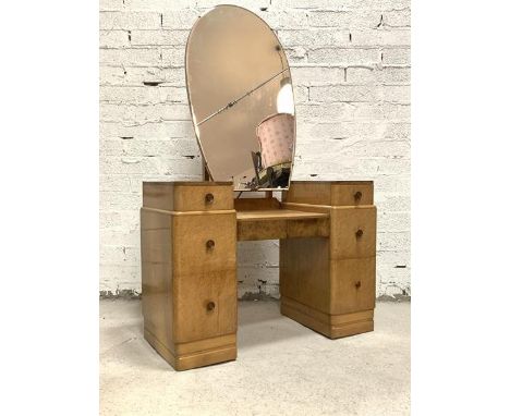 An Art Deco period bird eye maple twin pedestal dressing chest, the large bevelled swing mirror of ovoid form over two drawer