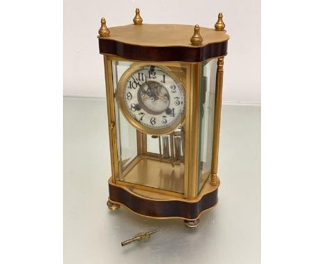 An Edwardian ormolu four glass mantel clock with enamel dial with visible escapement, with arabic numerals, twin key aperture