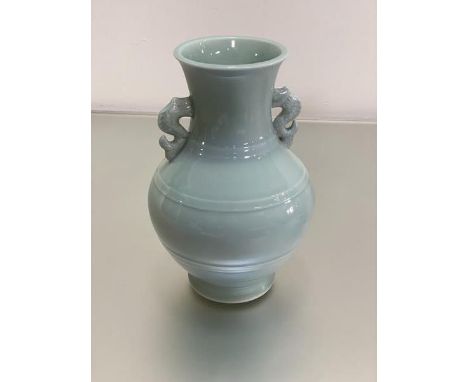 A modern Chinese celadon ware baluster vase with fish scroll handles to side (h.26cm)
