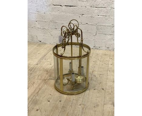 A cylindrical brass and glass four branch hanging lantern with chain and ceiling rose, H64cm D35cm