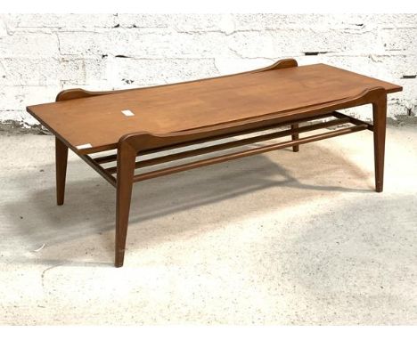 A Vintage mid century teak coffee table, the rectangular top raised on square tapered supports united by a magazine shelf und