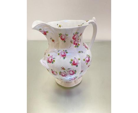A large 19thc china wash basin ewer of panelled design with C scroll handle to top, decorated with handpainted rose sprays an