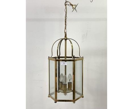 A brass hexagonal hanging lantern, with inset glass panels, six branches, chair and ceiling rose, H48cm