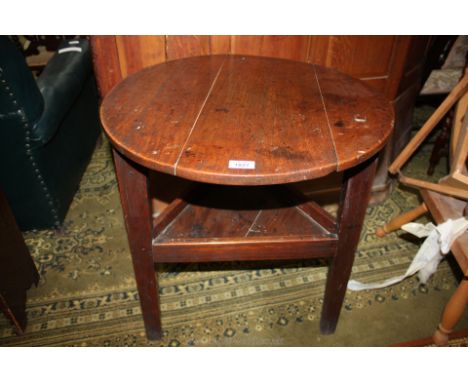 A good Oak peg joined Cricket Table, the three legs united by a triangular lower shelf with raised sides, 23 1/2'' diameter, 