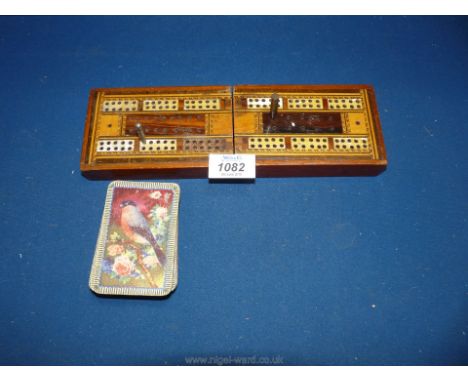 A 19th century mahogany folding cribbage board inlaid with boxwood, rosewood etc. with a pack of vintage playing cards.