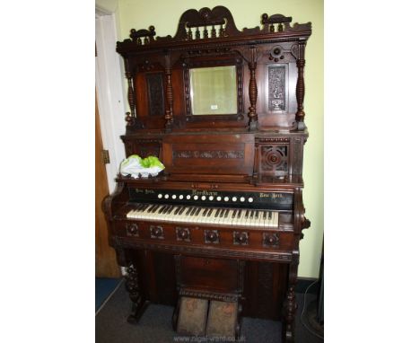 A Needham New York Harmonium supplied by Dale Forty and Co. Ltd., thirteen stops and 4 1/2 octave keyboard, complete with mir