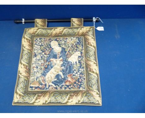 A small wall hanging Tapestry depicting a shepherdess with a lamb and her dog in the background, 16" x 15 1/2".