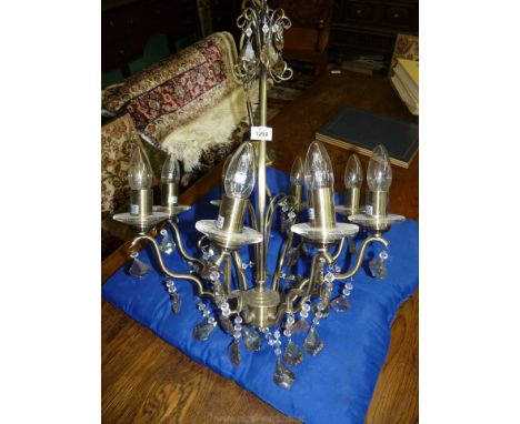 An eight branch chandelier, silver coloured with separate bag of crystals.