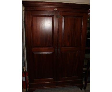 		A mahogany wardrobe enclosed by a pair of panel doors over two base drawers raised on bracket feet. 48' wide
