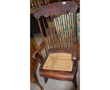 		A Stick back rocking chair with cane seat
