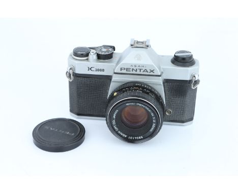 A Pentax K1000 SLR Camera, with Pentax-M f/2 50mm lens, shutter working, some light internal haze to lens