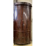 An unusually tall late 18th century Dutch mahogany bow fronted corner cabinet, in two sections,