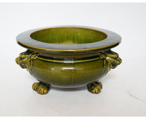 A green glazed Art pottery planter raised on three paw feet, diameter 20.5cm