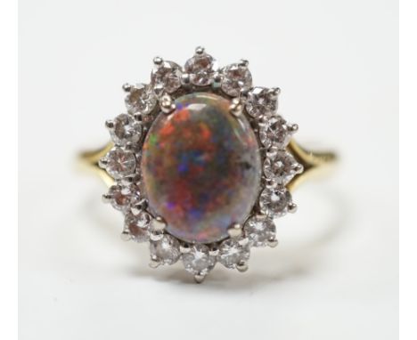 An 18ct, black opal and diamond set oval cluster ring, size P/Q, gross weight 5.4 grams. Fair condition.
