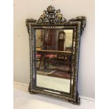 A French decorative wall mirror with cherub motifs, (later painted), width 81cm, height 127cm.
