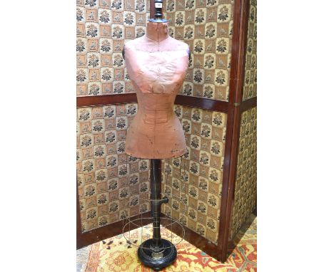 An early 1900s haberdasher's mannequin on adjustable ebonised stand, the base enclosed with wire cage, heart-shaped brass lab