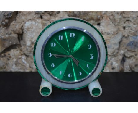 An Art Deco mantel clock with Swiss eight-day movement, the green engine turned enamel dial within an onyx and green stone ca