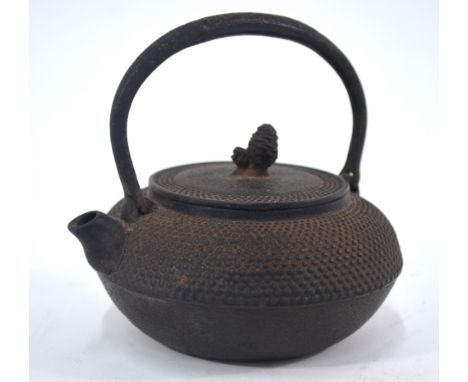 A Japanese shibui metal tetsubin with looped handle, cover and finial; 12 cm high, probably Taisho/Showa Jidei