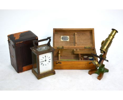 A small lacquered brass field microscope in fitted box and six 19th century prepared nature slides, to/w a French carriage cl