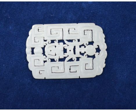 A small Chinese green jade pendant of whitish hue, designed with a key-fret pattern and reticulated motifs; about 4.5 x 3 cm,