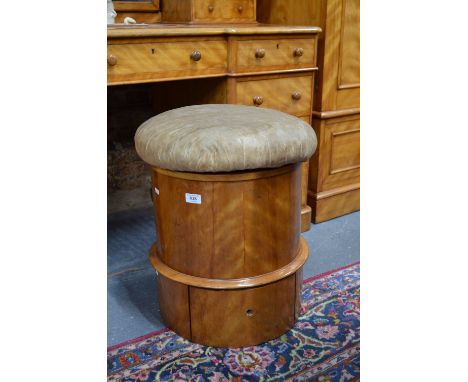 A Victorian satin-birch drum commode, the overstuffed hinged seat enclosing a fitted pottery commode with lid (showing damage