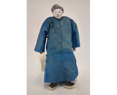 An interesting Chinese doll of a standing scholar or high ranking official; with a painted ceramic face, arms wrists and head