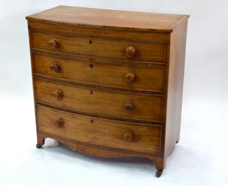 A 19th century Georgian mahogany bow-front chest of four long drawers, with turned wooden pulls, raised on shaped bracket fee