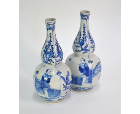 A pair of Chinese blue and white vases; each one of double gourd form decorated with two Manchu/Chinese beauties alternating 