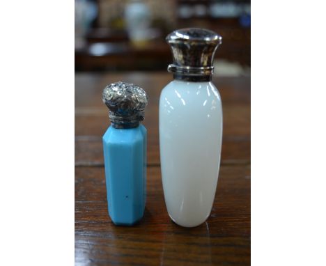 An opaque white glass ovoid scent flask with white metal collar and hinged cover, 9.5 cm, to/w a pale blue octagonal glass ex