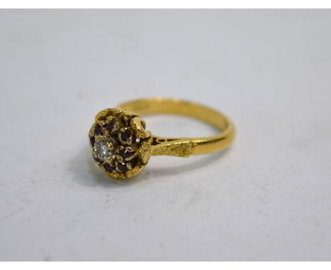 A ruby and diamond cluster ring in partly textured yellow metal setting stamped 18ct