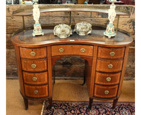 An Edwardian Sheraton Revival style satinwood inlaid walnut desk of kidney shape having a raised gallery upstand over a leath