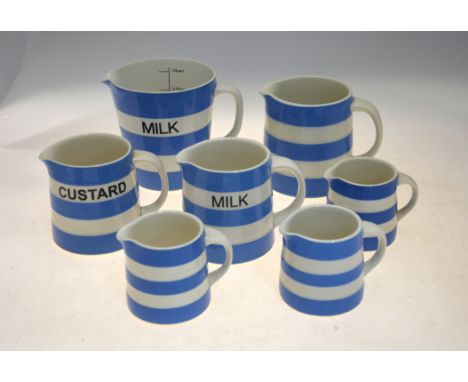 Seven T G Green Blue Cornish Ware jugs including a 1 One Quart milk measuring jug 'Restyled by Judith Onions', Custard and Mi
