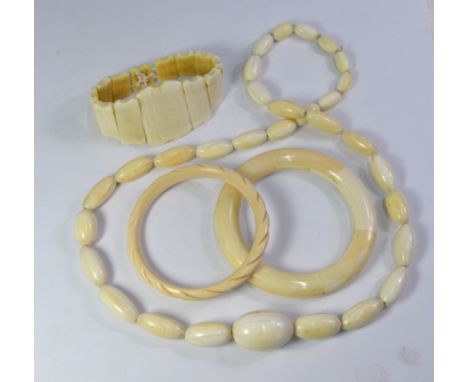 A collection of antique ivory jewellery including graduated beads, graduated bangle on elastic, and sectional bangle to/w sim