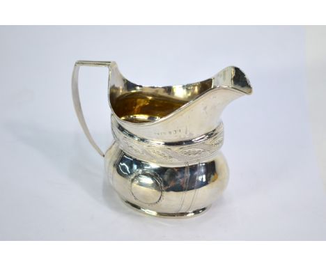 A George III silver helmet-shaped cream jug with bright-cut and wriggle-work decoration, maker TW, Newcastle (no date)Repairs