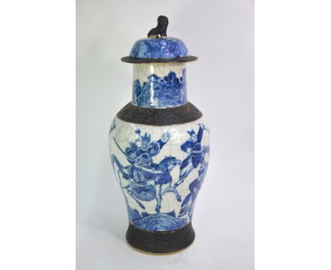 An underglaze blue decorated, Chinese vase with domed cover and Buddhist Lion finial, decorated with a narrative scene of war