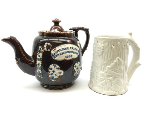 A 19th century Barge Ware teapot, decorated with applied floral sprays and thistles against a mottled brown ground, and plaqu