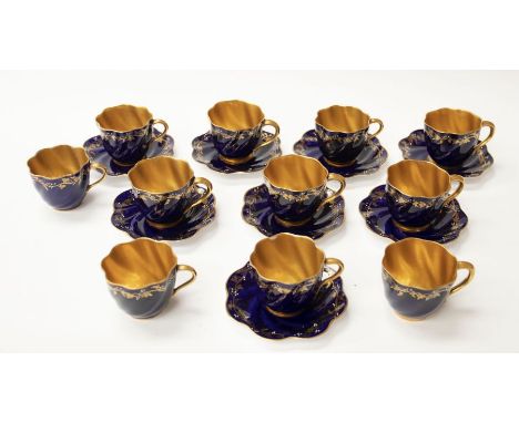 Coalport cups and saucers, floral sprig on blue ground, with gold lining, gilt loss to some pieces, seven saucers and eleven 