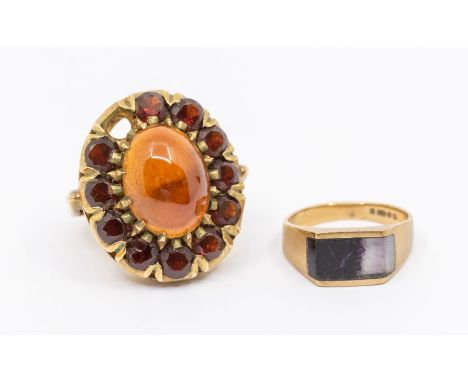 A garnet and 9ct gold cluster ring set to the centre with an oval cabochon garnet within a border of round mixed cut garnets,