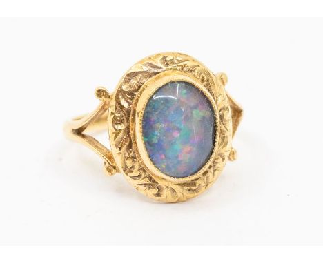 A 9ct gold opal doublet ring, oval shape opal triplet, with fancy decorative border, split scrolled shoulders, size N, total 