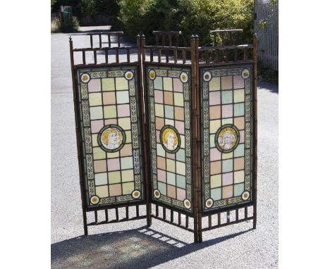 An Arts &amp; Crafts three fold large fire screen with simulated bamboo frame, the centre screens each with portrait medallio
