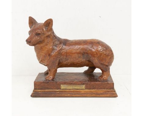 A Modern carved oak figure of a Corgi on raised plinth, brass plaque titled: Marapen Gladiator, the piece incised WH69 to bac