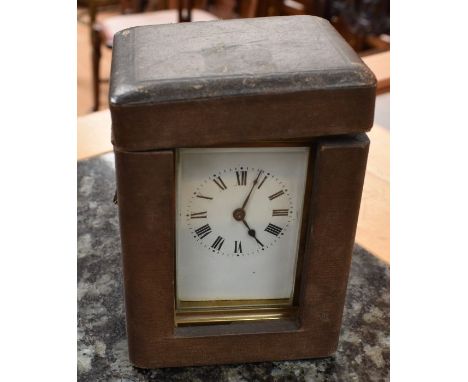 A French early 20th Century brass carriage clock with leather travel case, white enamel dial with Roman numerals, movement wi