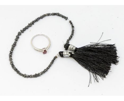 A 9ct white gold rubellite tourmaline and diamond ring, comprising a claw set oval cut rubellite to tapered shoulders grain s