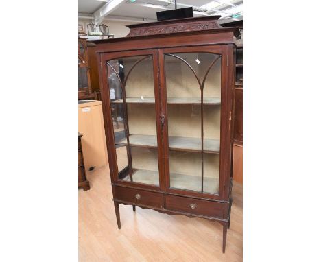 An Edwardian mahogany two shelf display cabinet on tapered legs, having glazed doors and sides