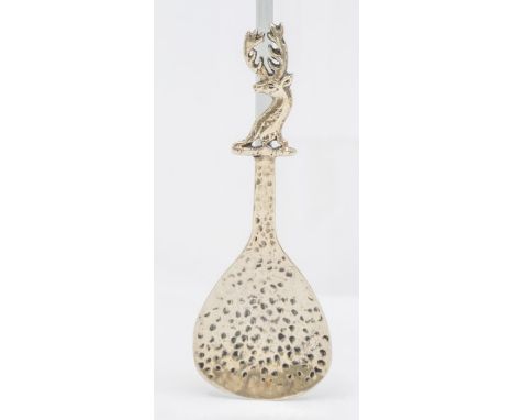 An Arts &amp; Crafts Scottish silver caddy spoon, hammered bowl with Stag's head crest terminal, hallmarked by Henderson &amp