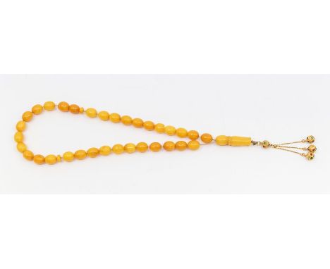 An egg yolk amber type bead necklace, oval beads approx 10 x 12mm, with amber toggle to front (some chips and damage to toggl