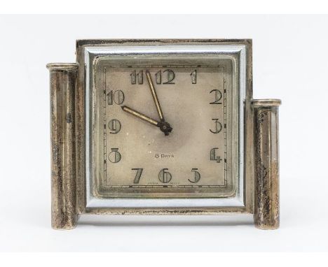 An Art Deco silver mounted 8 day desk clock, with luminous Arabic numbers and hands, plain square body with stepped side supp