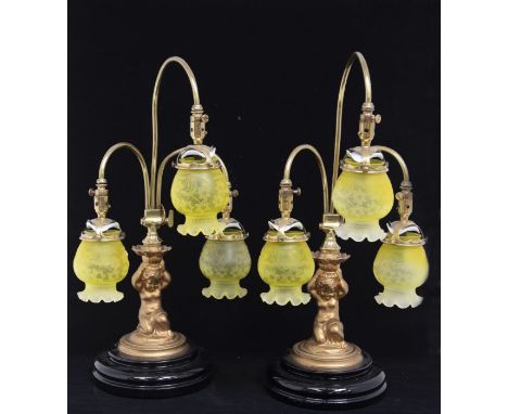 A pair of Victorian style gilt metal three light table lamps, curved stems with etched yellow opaline glass shades, the centr