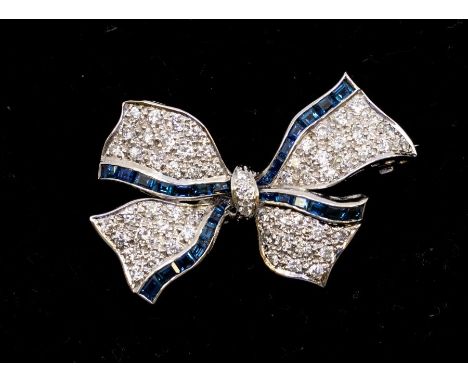 A sapphire and diamond 18ct white gold bow brooch comprising a ground of round brilliant cut pave set diamonds with borders o